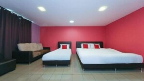 A hotel room with two beds, a sofa, and a red accent wall. - Hotel Inn (Durian Sebatang)