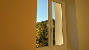 A room with a window overlooking a forested area. - Country house in the heart of the Parc des Volcan, 10 minutes from Clermont-Ferrand (Romagnat)