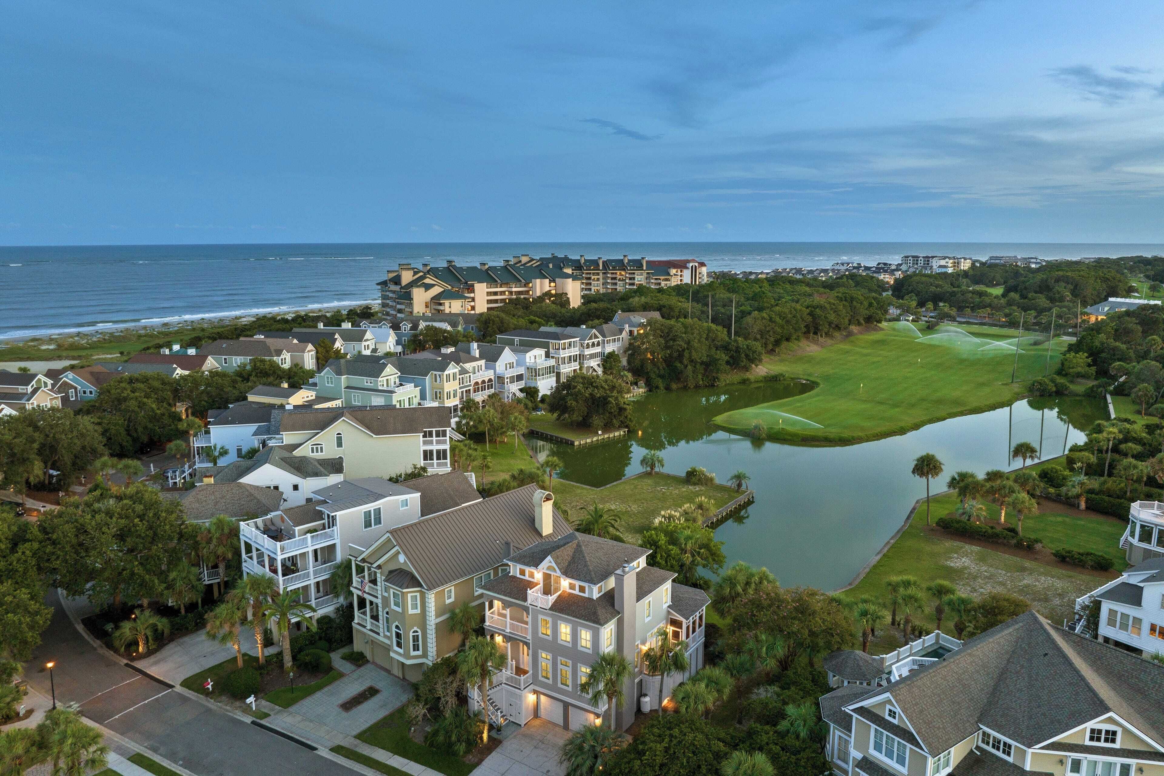 A residential area with houses, a golf course, and a body of water.