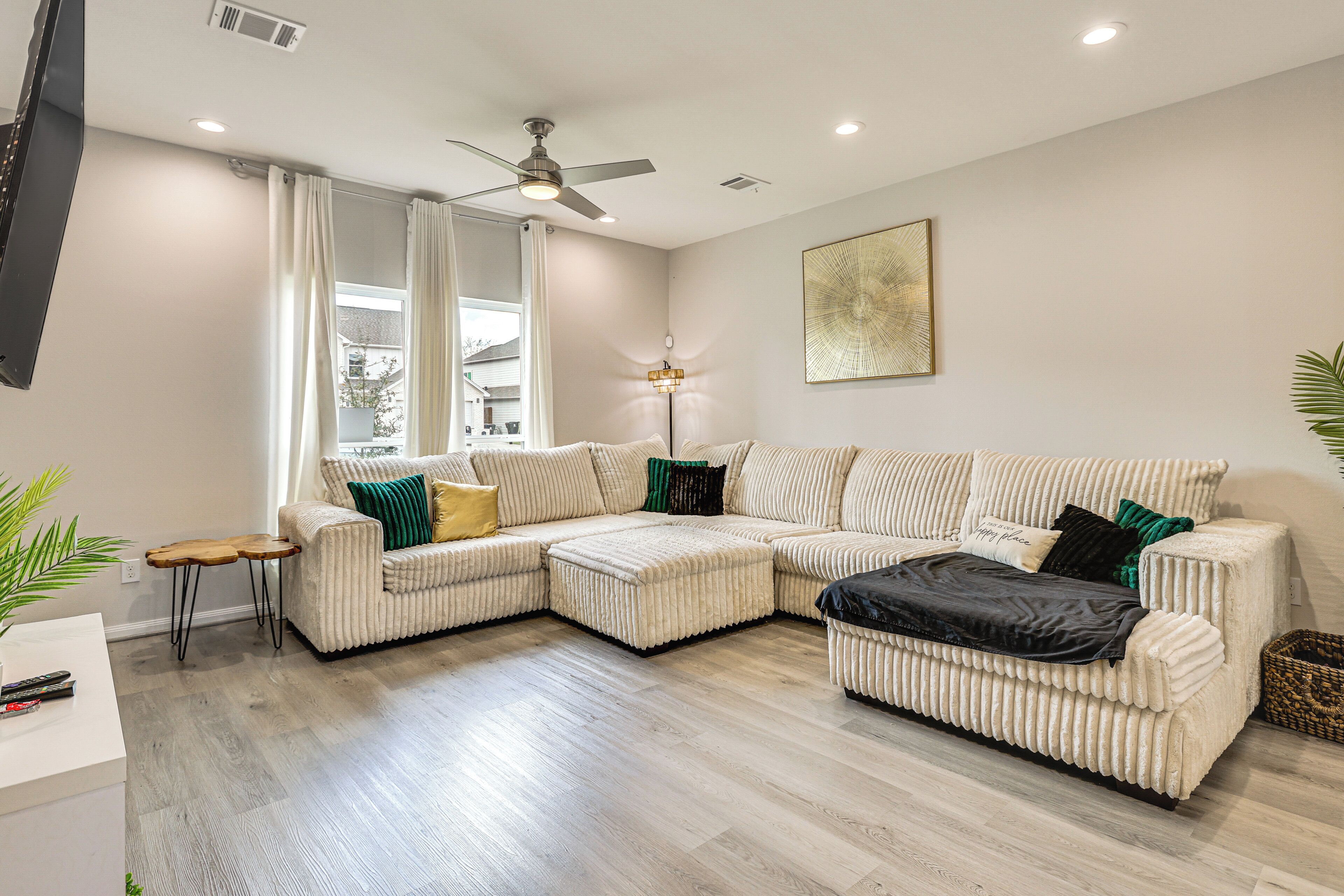 A modern living room with a sectional sofa, a small side table, and a floor lamp.