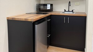 A compact kitchen with a built-in microwave, a dishwasher, and a sink. - Caleno Boricua apartment. Modern luxury apartment 5 minutes from the beach (Quebradillas)