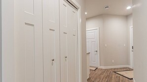 A hallway with white doors, wooden flooring, and recessed ceiling lighting. - Cozy 3bd/2ba House in Horace (Horace)