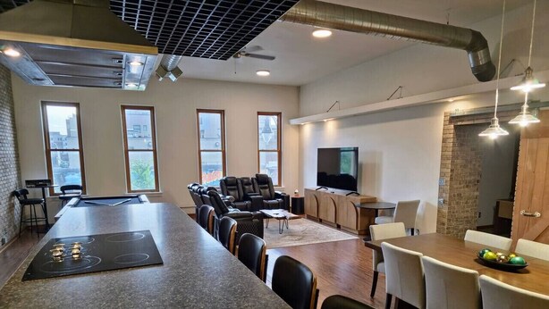 A modern kitchen with a large island, dining area, and seating. - Downtown Depot - Unit 5 (Fargo)