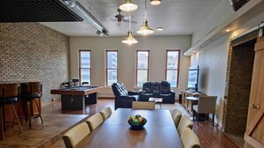 A spacious meeting room with a long table, comfortable seating, and large windows. - Downtown Depot - Unit 5 (Fargo)