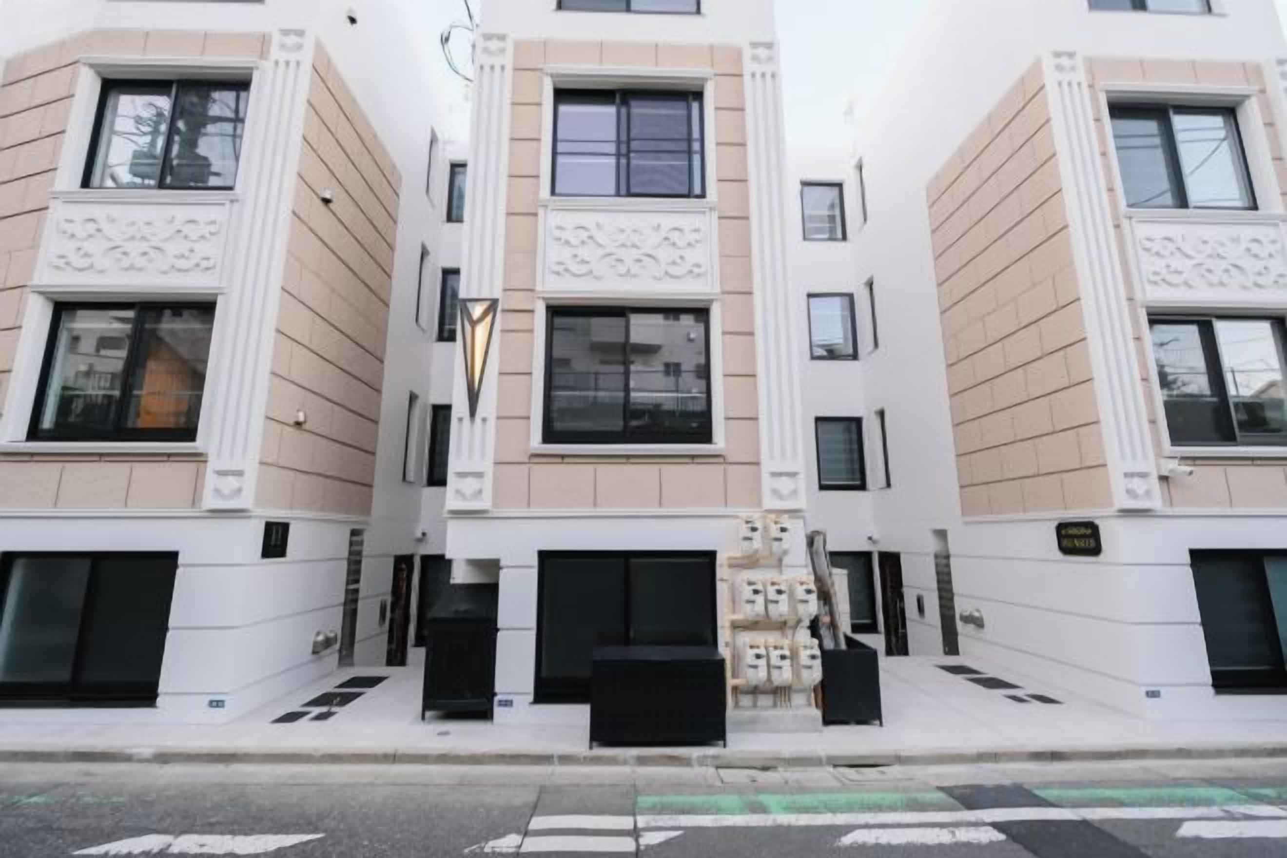 A modern building with a symmetrical facade, large windows, and a central entrance with steps.