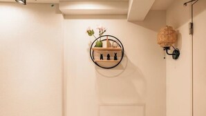 A wall-mounted shelf with decorative items and a wall sconce. - Mi-Hotel Qualia Shinjuku (Tokyo)