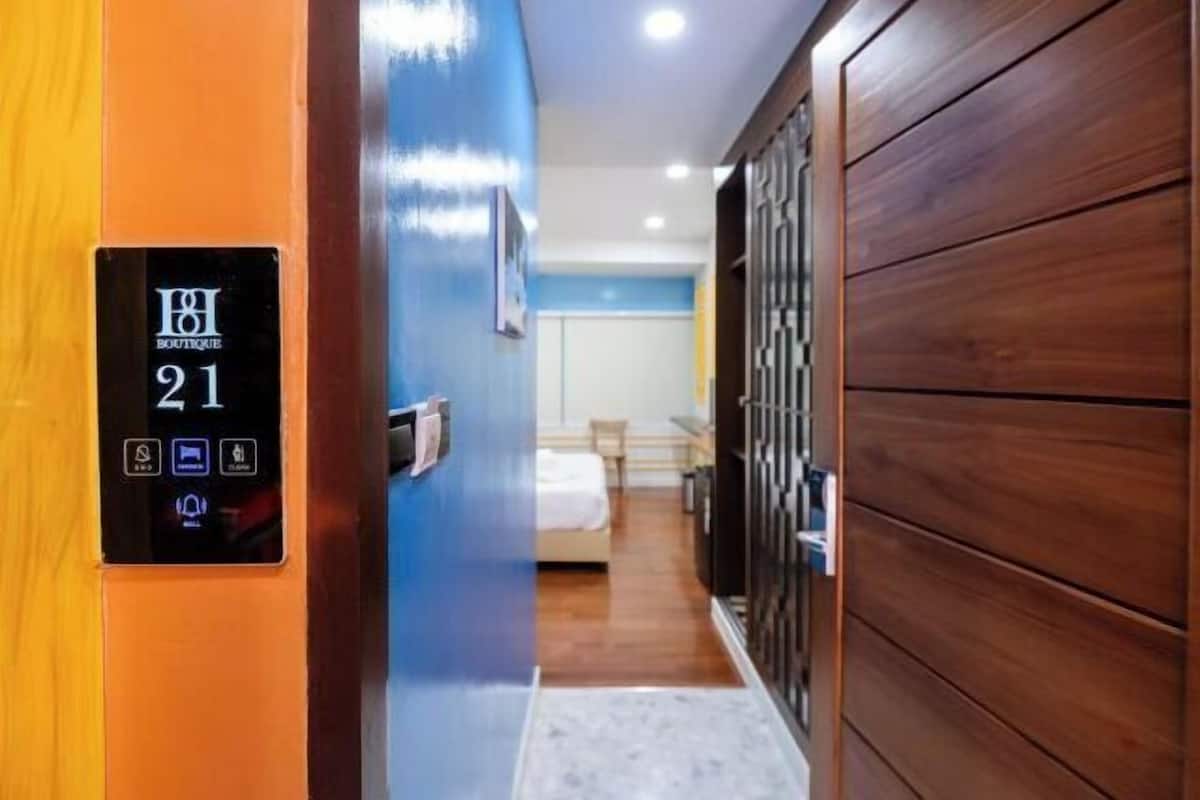 Une chambre d’hôtel équipée d’un lecteur de carte d’accès numérique, d’un lit, d’un bureau et d’une armoire.