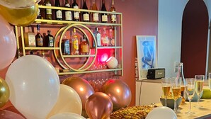 A bar area with a wall of balloons, shelves of liquor bottles, and a display of glasses and bottles. - Large house with swimming pool - sleeps 13, sleeps 25 - near Paris (rebais)