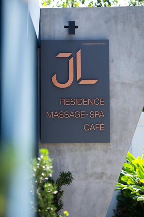 Letrero de un alojamiento con servicios de masajes, spa y cafetería.