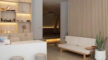A modern hotel lobby with a reception desk, seating area, and built-in shelving.