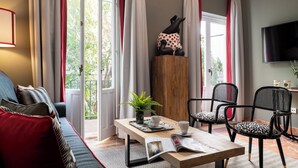 Un salon confortable avec un canapé, des fauteuils, une table basse et un téléviseur.