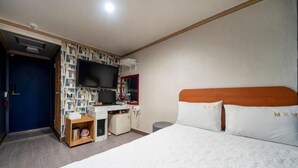 A hotel room with a bed, a desk, a television, and a wardrobe. - Sindang M (Seoul)