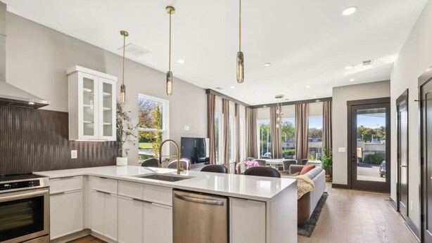 A modern kitchen with a central island, stainless steel appliances, and pendant lighting. - East Nash Luxury Escape w/Rooftop Deck-Sleeps 12! (Nashville)