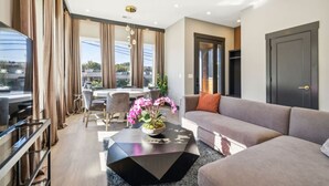 A modern living room with a sofa, coffee table, and dining area.