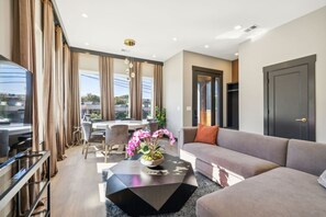 A modern living room with a sofa, coffee table, and dining area.