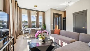 A modern living room with a sofa, a dining table with chairs, and a coffee table with a plant. - East Nash Luxury Escape w/Rooftop Deck-Sleeps 12! (Nashville)