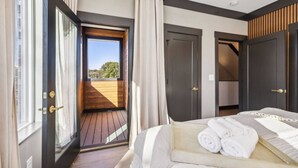 A bedroom with a bed, a window, and a door leading to a balcony. - East Nash Luxury Escape w/Rooftop Deck-Sleeps 12! (Nashville)