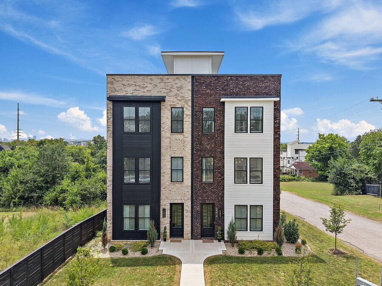 A modern multi-story building with a mix of brick and white facades, large windows, and a central entrance.