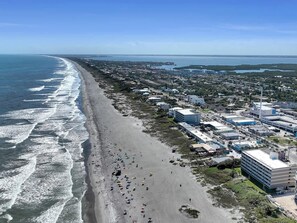 Een kuststadsgezicht met een strand, gebouwen en een heldere lucht.