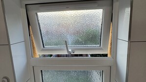 Una ventana con un panel de vidrio esmerilado y un tirador.