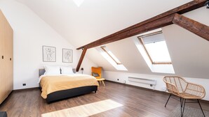 A bedroom with a bed, a chair, and a skylight. - Toompea Castle 2-Storey Unique Apartment (Tallinn)