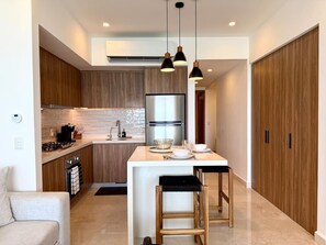 A modern kitchen with a central island, stainless steel appliances, and pendant lighting. - Beachfront Harbor171 Condo | Ocean-View Balcony & Rooftop Pool (Puerto Vallarta)