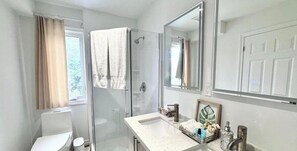 A bathroom with a shower, toilet, and sink. - Bentley Commons Fallsview Towns (Niagara Falls)