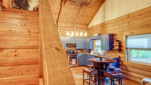 Interno di una cabina con angolo cottura, zona pranzo e ventilatore a soffitto.