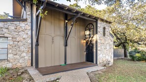 A stone building with a wooden deck, a black door, and a number "907" on the wall. - 4 mi to Aggieland, Yard & Deck (Bryan)