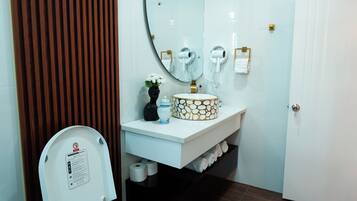 Un baño moderno con inodoro, lavabo, espejo y paneles de madera.