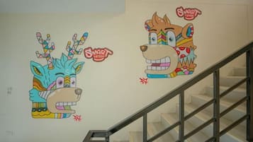A staircase with a handrail and a wall with two cartoon animal murals.