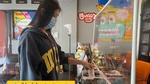 A person at a counter with a sign that reads "Smart Check Out". - Smart Hotel (Lam Luk Ka)