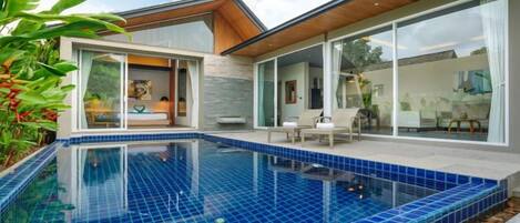 Una casa moderna con piscina, ventanas amplias y una zona de patio.