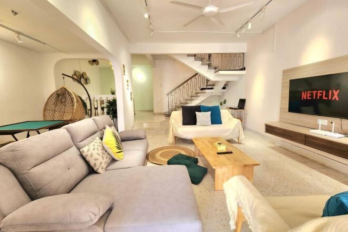 A modern living room with a sofa, coffee table, and a TV displaying 'NETFLIX'.