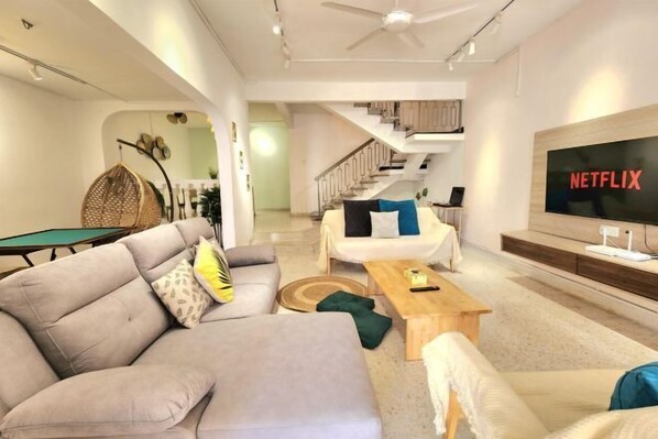 A modern living room with a sofa, coffee table, and a TV displaying 'NETFLIX'. - Damansara Jaya Petaling Jaya 2 Storey Landed House for 15 Pax (Petaling Jaya)
