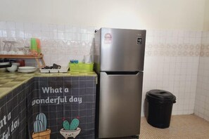 A kitchen with a stainless steel refrigerator, a trash bin, and a tiled backsplash. - Damansara Jaya Petaling Jaya 2 Storey Landed House for 15 Pax (Petaling Jaya)