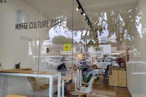A cafe interior with a glass wall, a table, chairs, and a sign reading 'MATTE CULTURE CAFE'. - Damansara Jaya Petaling Jaya 2 Storey Landed House for 15 Pax (Petaling Jaya)