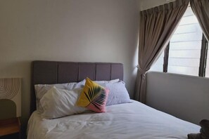 A bed with a headboard, pillows, and a window with curtains. - Damansara Jaya Petaling Jaya 2 Storey Landed House for 15 Pax (Petaling Jaya)