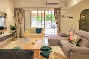A living room with a sofa, a coffee table, and a television. - Damansara Jaya Petaling Jaya 2 Storey Landed House for 15 Pax (Petaling Jaya)