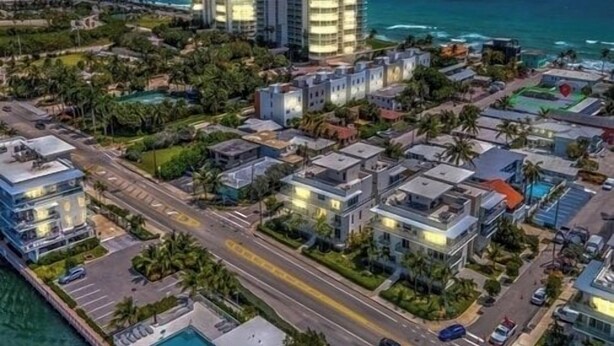 An aerial view of a coastal residential area with modern buildings, a road, and a view of the ocean. - Dania Beach Getaway 2 Studios for 6 Guests (Hollywood)