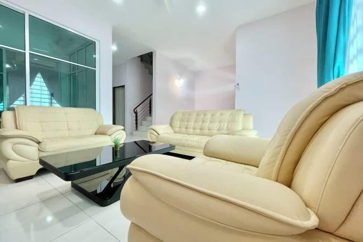 Ein modernes Wohnzimmer mit zwei beigefarbenen Sofas, einem Glastisch und einem großen Fenster mit Blick.