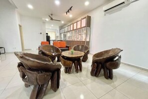 A modern living room with a central round table surrounded by four unique wooden chairs, a ceiling fan, and a large window with blinds. - Langkawi Cozy Holiday Home at Taman Simfoni by Zervin (Langkawi)