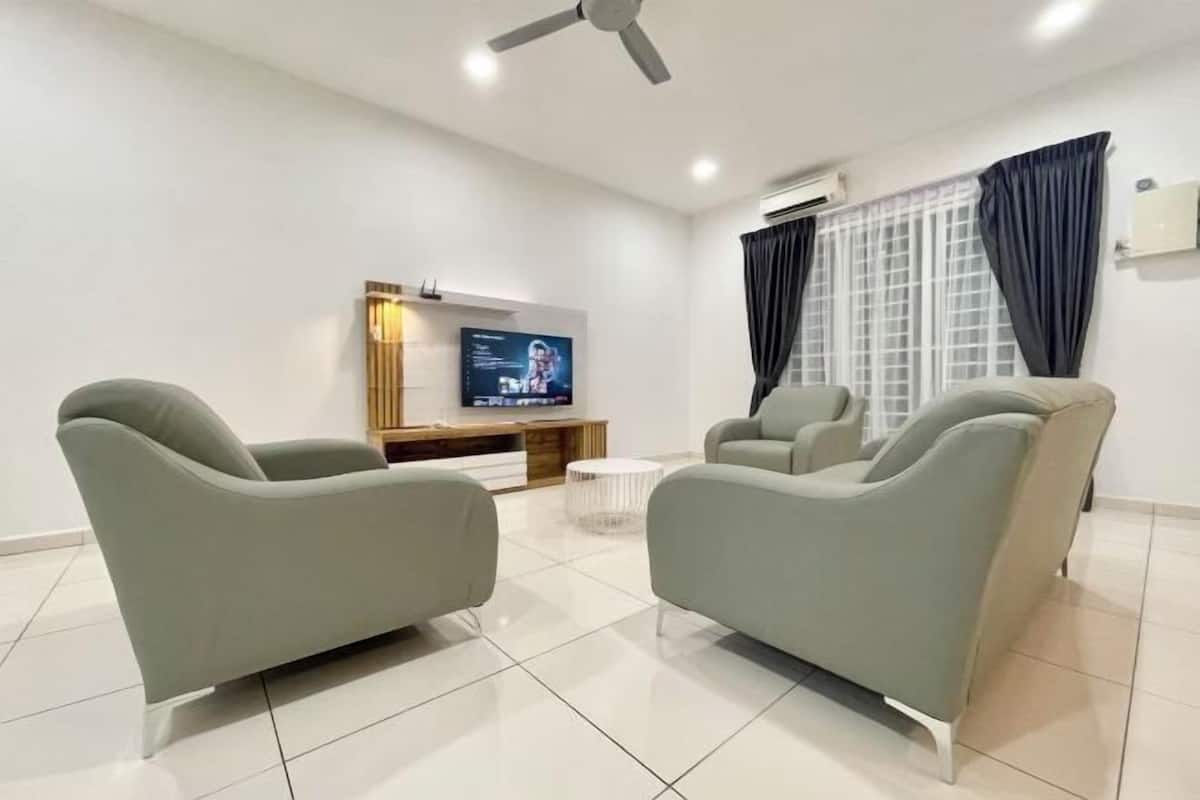 Ein modernes Wohnzimmer mit zwei Sofas, einem Fernseher und einem Deckenventilator.