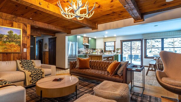 A cozy living room with a fireplace, a dining area, and a kitchen. - Lux Hot Tub Cabin w Fire Pit (Napanoch)