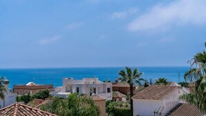 Un área residencial costera con edificios, palmeras y vista al mar.