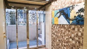 A hotel entrance with a tiled wall, a glass door, and a staircase leading outside. - J-Court Oshiage (Tokyo)
