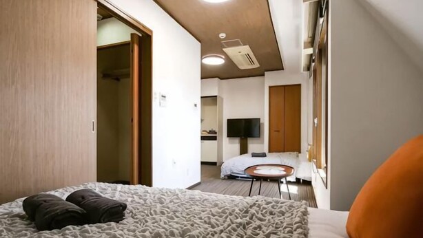 A hotel room with a bed, a desk, a chair, a TV, and a bathroom. - J-Court Oshiage (Tokyo)