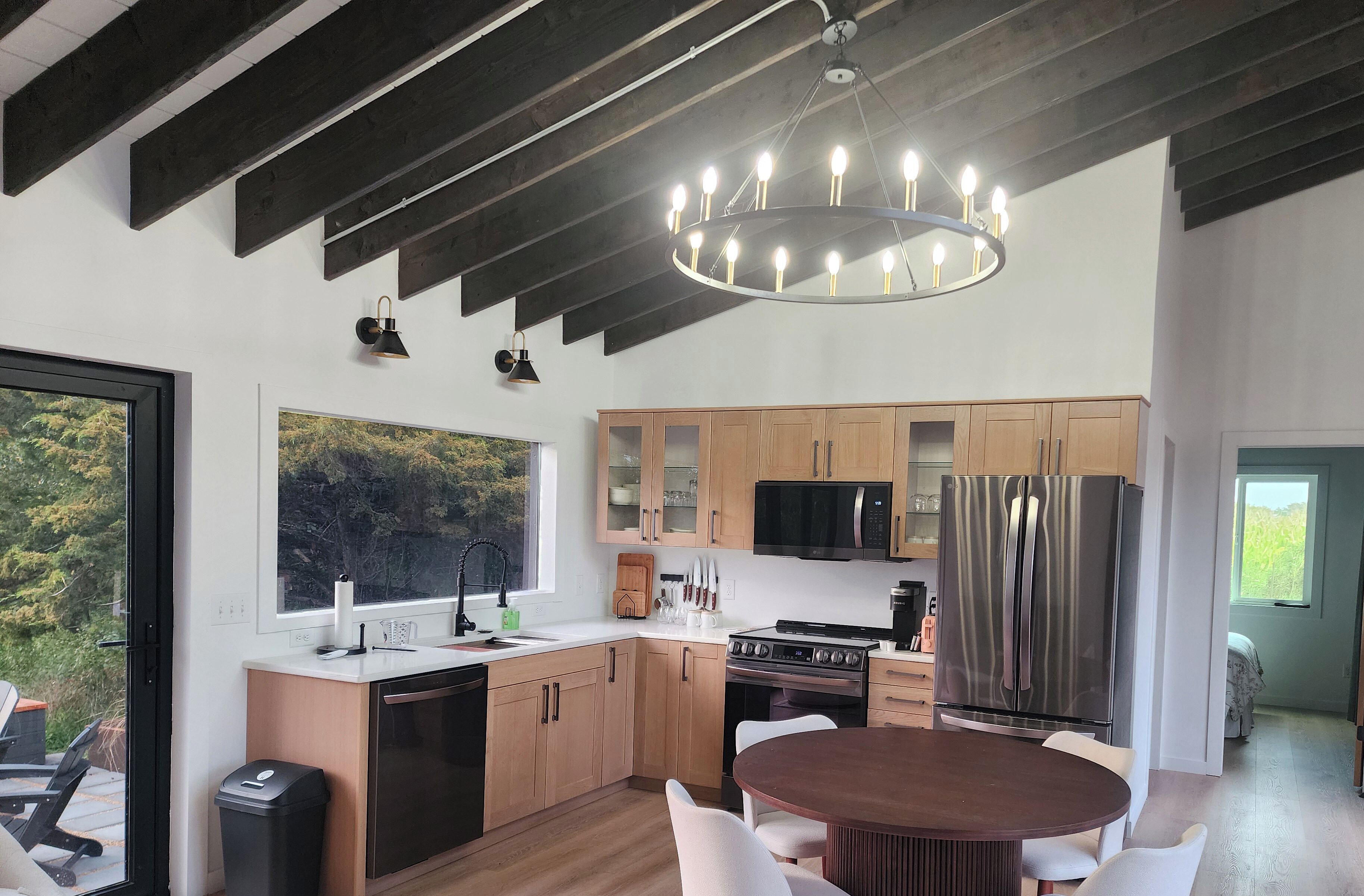 Una cocina moderna con armarios de madera, un refrigerador de acero inoxidable y un ventanal grande.