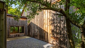 Une structure en bois avec un chemin de gravier, un banc et une fenêtre.