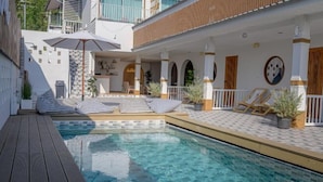 A poolside area with a wooden deck, lounge chairs, and a clear pool. - Le Soleil Koh Larn (Koh Larn)